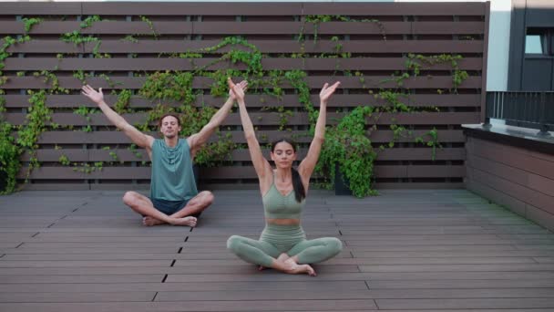 Concentrated Couple Athletes Meditating Yoga Mat Closed Eyes Hotel Balcony — стоковое видео