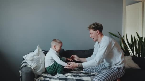 Вид Сбоку Молодого Счастливого Отца Играющего Сыном Диване Дома — стоковое видео