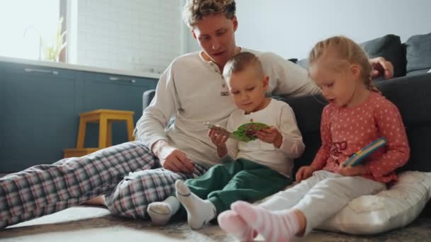 Θετικός Πατέρας Μιλάει Γιο Και Την Κόρη Ενώ Διαβάζει Βιβλία — Αρχείο Βίντεο