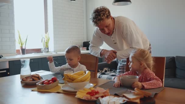 Smiling Young Curly Haired Father Talking Children Who Eating Breakfast — Stock Video