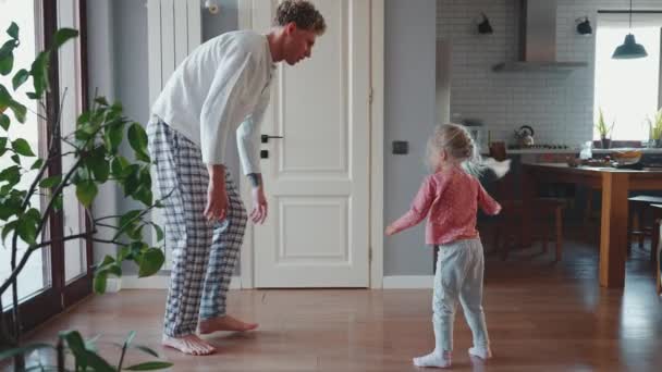 笑顔のカーリーハイレッドブロンドの父親は娘と遊び ダンスをし 自宅で手で抱っこする彼女を投げます — ストック動画