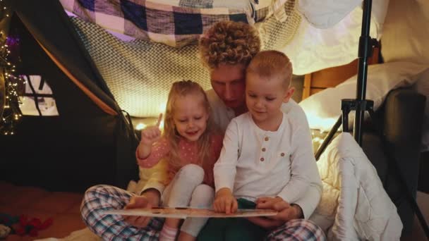有自信的卷曲金发父亲回家前给儿子和女儿读童话故事 — 图库视频影像