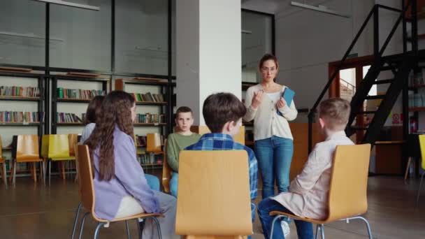 Profesora Segura Habla Con Niños Sentados Círculo Sillas Clase Escuela — Vídeo de stock