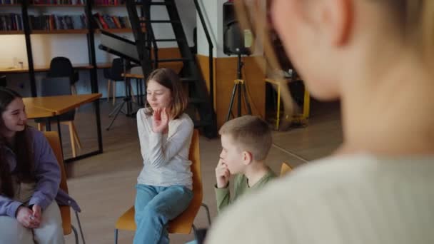 Crianças Felizes Jogando Jogo Gesto Enquanto Sentado Círculo Cadeiras Biblioteca — Vídeo de Stock