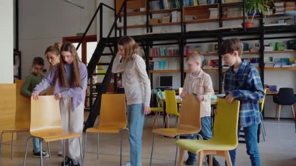 Przystojne Dzieci Ustawić Krzesła Kółko Przed Grą Nauczycielem Bibliotece Szkole — Wideo stockowe
