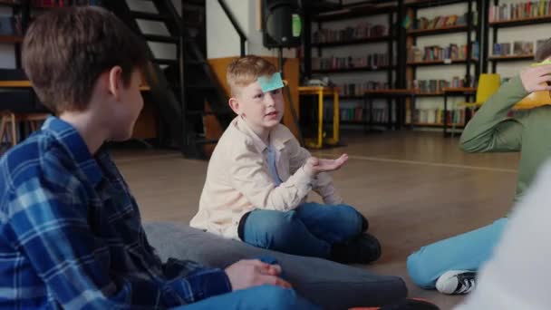 Kendine Güvenen Çocuklar Tahmin Edin Ben Kimim Alnımda Kağıtlarla Kütüphanede — Stok video