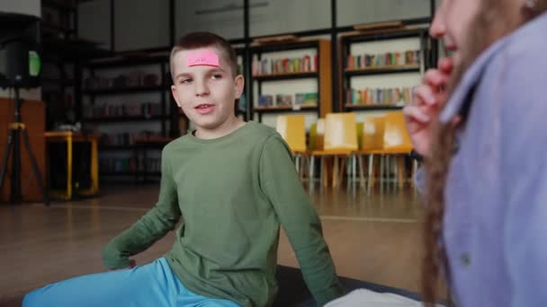 Güzel Esmer Çocuk Tahmin Ben Kimim Alnımda Kağıtlarla Kütüphanede Daireler — Stok video