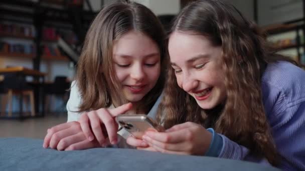 Okuldaki Kütüphanede Cep Telefonuyla Mesajlaşan Neşeli Genç Kızlar — Stok video