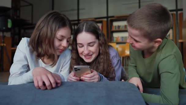 Okulda Kütüphanede Cep Telefonuyla Mesajlaşan Mutlu Çocuklar — Stok video