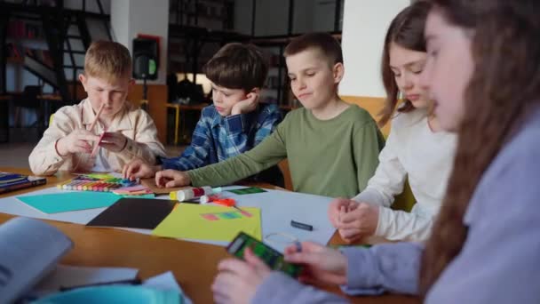 Koncentrált Gyerekek Rajz Zsírkrétával Készül Origami Asztalnál Könyvtárban — Stock videók