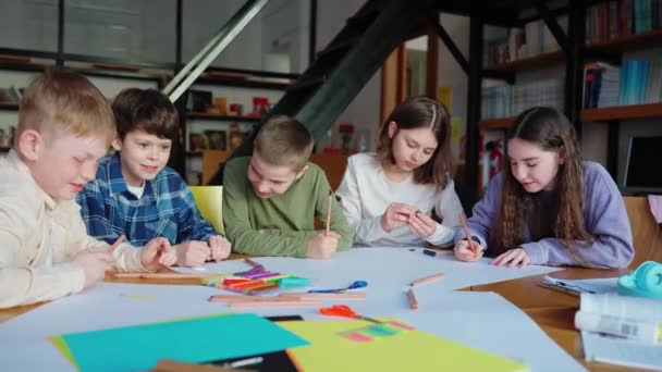 鉛筆で絵を描いて図書館で話す陽気な子供たち — ストック動画
