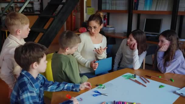 Серьезный Учитель Разговаривает Детьми Столом Рисования Библиотеке — стоковое видео