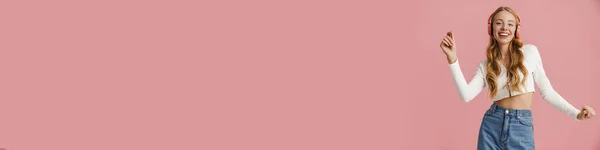 Весела Молода Блондинка Слухає Музику Бездротовими Навушниками Ізольовані Рожевому Фоні — стокове фото