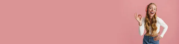 Веселая Молодая Блондинка Слушает Музыку Беспроводными Наушниками Изолированы Розовом Фоне — стоковое фото