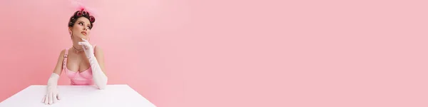 Молодая Женщина Перчатках Смотрит Сторону Сидя Столом Изолированы Розовом Фоне — стоковое фото