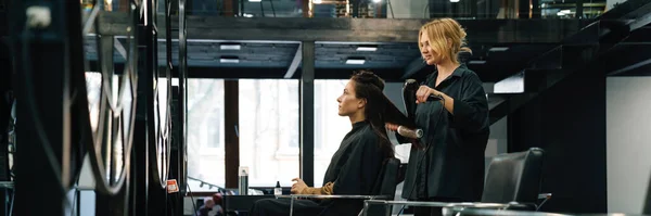 年轻的金发女人在美容院为客户做发型 — 图库照片