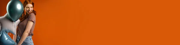 Gember Vrolijke Vrouw Glimlachen Terwijl Poseren Met Ballonnen Geïsoleerd Oranje — Stockfoto