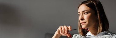 Gülümseyen orta yaşlı bir kadın kanepeye oturmuş, elinde bardaklarla başka yere bakıyor.