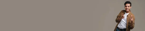 Брюнет Шиплячий Чоловік Сорочці Посміхається Вказує Пальці Камеру Ізольовані Сірому — стокове фото