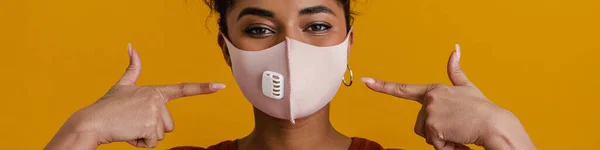 Black Woman Looking Camera While Pointing Finger Her Face Mask — Stockfoto