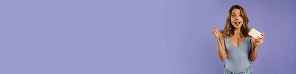 Молода Біла Жінка Радіє Тримає Мобільний Телефон Ізольовано Фіолетовому Фоні — стокове фото