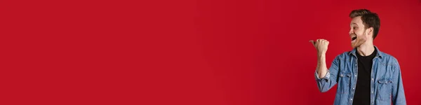 Kırmızı Duvarın Arkasında Dikilip Fotokopi Alanını Işaret Eden Gündelik Kıyafetli — Stok fotoğraf