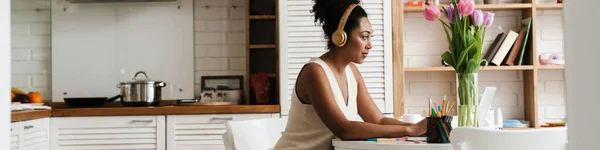 Mulher Negra Fones Ouvido Trabalhando Com Laptop Enquanto Senta Mesa — Fotografia de Stock