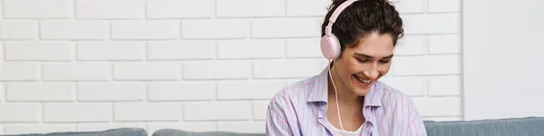 Ευτυχισμένη Γυναίκα Ακουστικά Κάθεται Μπροστά Από Ένα Φορητό Υπολογιστή Και — Φωτογραφία Αρχείου