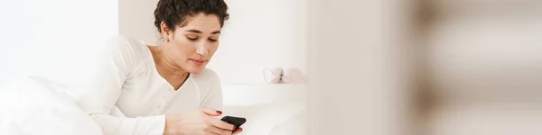 Den Förvånade Kvinnan Tittar Telefonen Medan Hon Ligger Sängen Vit — Stockfoto