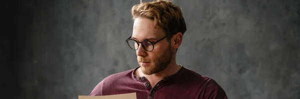 Сосредоточенный Человек Очках Сидящий Столом Листая Бумаги Студии — стоковое фото