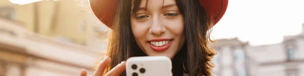 Gledelig Ung Brunette Hvit Kvinne Som Står Gaten Med Mobiltelefon – stockfoto