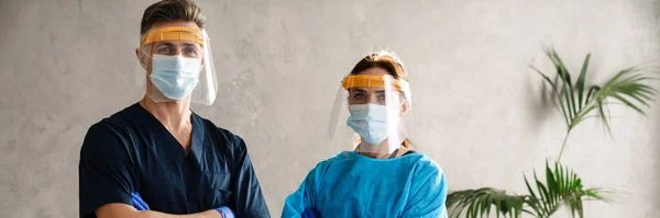 Dos Trabajadores Médicos Vestidos Uniforme Pie Interior Con Túnicas Máscaras —  Fotos de Stock