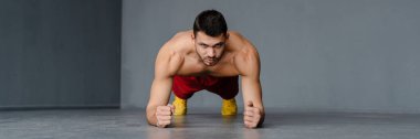 Genç üstsüz sporcu içeride çalışırken egzersiz yapıyor.