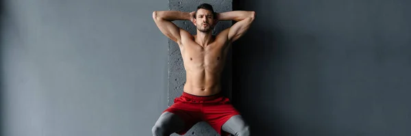 stock image Young shirtless sportsman doing exercise with expander stretch tape indoors