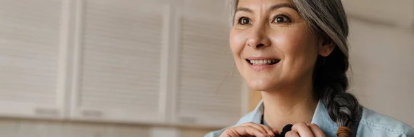 Mature Grey Woman Smiling Fastening Microphone Herself Home — ストック写真