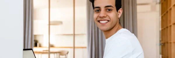 Sorrindo Jovem Hispânico Que Trabalha Estudando Computador Portátil Enquanto Está — Fotografia de Stock