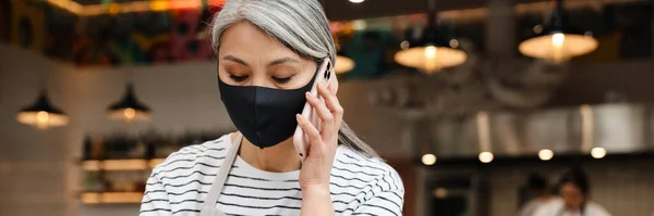 Gammal Servitris Kvinna Bär Ansiktsmask Talar Mobiltelefon När Arbetar Vid — Stockfoto