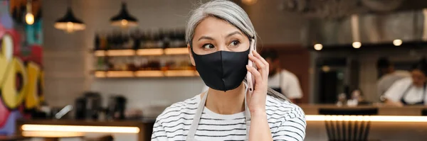 Gammal Servitris Kvinna Bär Ansiktsmask Talar Mobiltelefon När Arbetar Vid — Stockfoto
