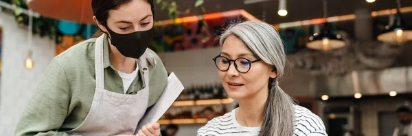 Young Waitress Woman Wearing Face Mask Showing Menu Her Client — Stock Photo, Image