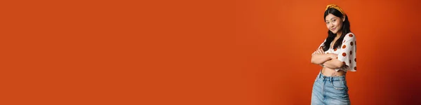 Lächelnde Junge Asiatin Sommerkleidung Vor Orangefarbenem Hintergrund Die Arme Verschränkt — Stockfoto