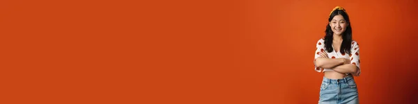 Улыбающаяся Молодая Азиатка Летней Одежде Стоящая Оранжевом Фоне Сложенные Руки — стоковое фото