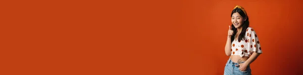 Улыбающаяся Молодая Азиатка Летней Одежде Стоящая Оранжевом Фоне — стоковое фото