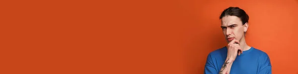 Молодой Белый Мужчина Серёжкой Хмурясь Глядя Камеру Изолированы Оранжевом Фоне — стоковое фото
