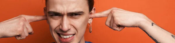 Young White Man Earring Frowning Plugging His Ears Isolated Orange — Stock Photo, Image