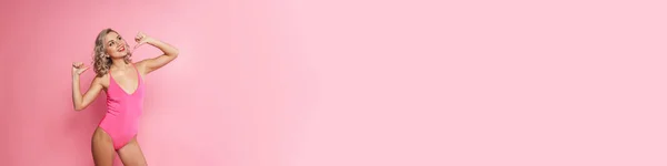 Egy Mosolygó Szőke Portréja Fürdőruhában Amint Rózsaszín Fal Fölött Áll — Stock Fotó
