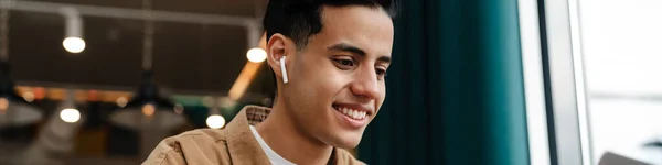 Молодой Улыбчивый Латиноамериканец Сидит Столом Кафе Ноутбуком Помещении Видеозвонке — стоковое фото