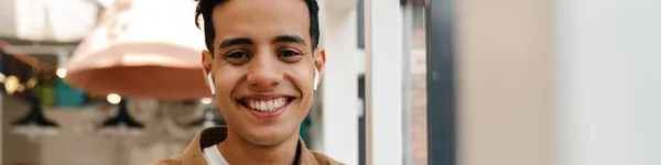 Smiling Pemuda Hispanik Pria Earphone Pada Panggilan Video Melalui Ponsel — Stok Foto