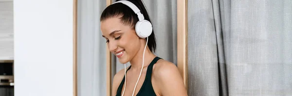 Усміхнена Молода Біла Жінка Спортивному Одязі Навушниках Слухає Музику Тримає — стокове фото