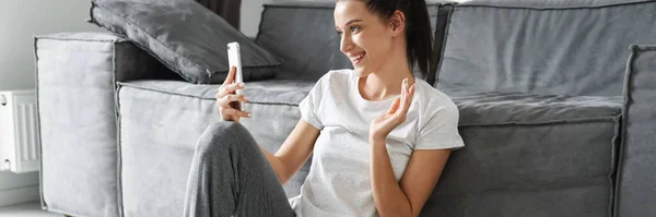 Mulher Sorridente Gesticulando Usando Telefone Celular Enquanto Sentado Chão Casa — Fotografia de Stock