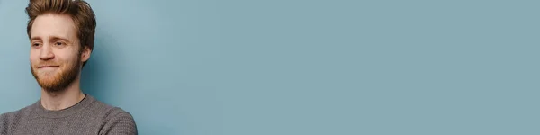 Білий Імбирний Чоловік Бородою Посміхається Дивиться Вбік Ізольовано Синьому Фоні — стокове фото